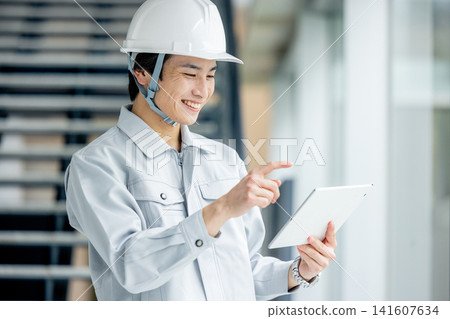 A young man wearing work clothes A young man wearing work clothes 141607634