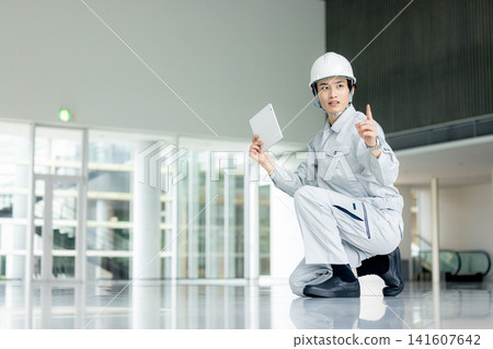 A young man wearing work clothes A young man wearing work clothes 141607642