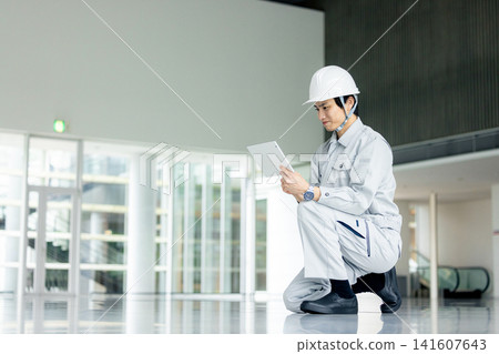 A young man wearing work clothes A young man wearing work clothes 141607643