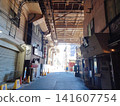 The shops along the walkway, crisscrossed with power lines, are directly above the JR railway overpass, which is currently under construction. 141607754