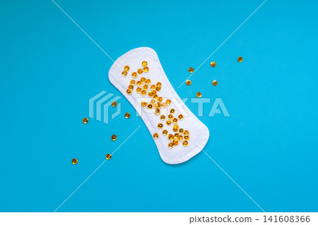 Sanitary Pad with Gold Sequins Representing Urinary Leakage on Blue Background Sanitary Pad with Gold Sequins Representing Urinary Leakage on Blue Background 141608366