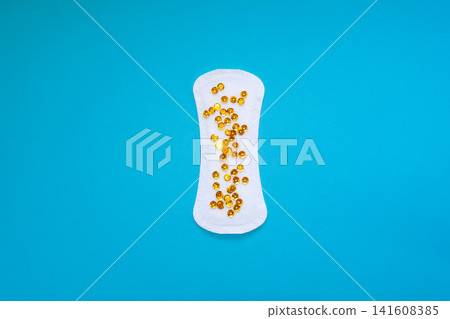 Sanitary Pad with Gold Sequins Representing Urinary Leakage on Blue Background Sanitary Pad with Gold Sequins Representing Urinary Leakage on Blue Background 141608385