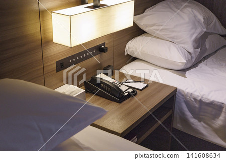 Hotel room bedside table and landline telephone Hotel room bedside table and landline telephone 141608634