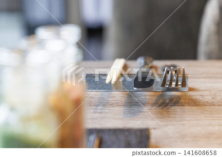 餐桌上擺放著餐具和調味料罐。 餐桌上擺放著餐具和調味料罐。 141608658