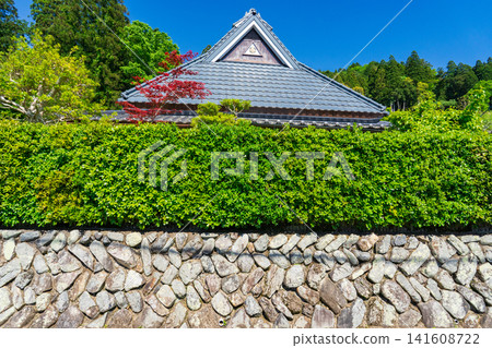 A traditional Japanese house with a corrugated iron roof stands out against the blue sky in Ohara, Kyoto. A traditional Japanese house with a corrugated iron roof stands out against the blue sky in Ohara, Kyoto. 141608722
