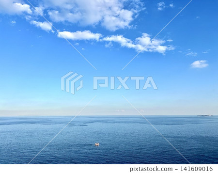 一艘孤零零的船漂浮在浩瀚的海洋上,背景是蔚藍的天空。地平線影像,風景,庫存照片。晴空萬裡。 一艘孤零零的船漂浮在浩瀚的海洋上,背景是蔚藍的天空。地平線影像,風景,庫存照片。晴空萬裡。 141609016