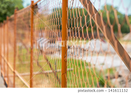 [#ConstructionSite] Close-up of a construction site lined with orange fences 141611132