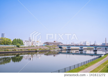 A riverbed landscape with a gentle flow of the river and a clear blue sky. 141611272
