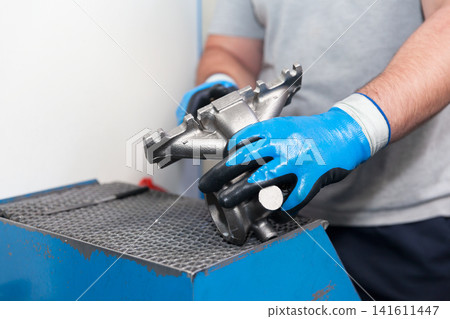 Automotive worker holding new part of car engine Automotive worker holding new part of car engine 141611447