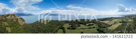 Rocca di Manerba, olive groves and Lake Garda in an ultra wide drone panorama Rocca di Manerba, olive groves and Lake Garda in an ultra wide drone panorama 141611723