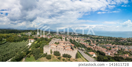 Padenghe Castle roofs and walls in a close drone panorama over the lakeside town Padenghe Castle roofs and walls in a close drone panorama over the lakeside town 141611728