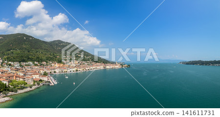 Wide drone panorama with Salo shoreline receding beside open Lake Garda Wide drone panorama with Salo shoreline receding beside open Lake Garda 141611731