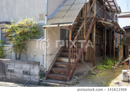 A Showa-era apartment building with an external staircase before it was demolished. A Showa-era apartment building with an external staircase before it was demolished. 141611906