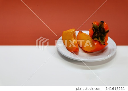 Persimmon fruit on two-colored background. 141612231