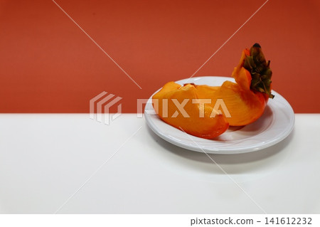 Persimmon fruit on two-colored background. 141612232