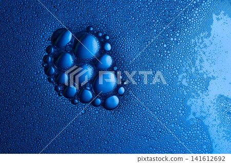 Blue water surface showing soap bubbles and foam creating a macro abstract liquid texture Blue water surface showing soap bubbles and foam creating a macro abstract liquid texture 141612692
