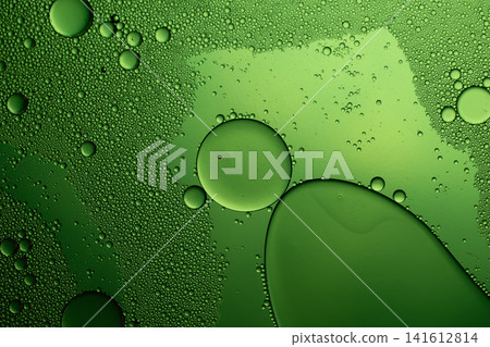 Oil drops creating an abstract pattern on a green liquid surface, macro view Oil drops creating an abstract pattern on a green liquid surface, macro view 141612814