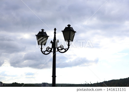 A vintage-style street lamp under a cloudy sky. A vintage-style street lamp under a cloudy sky. 141613131