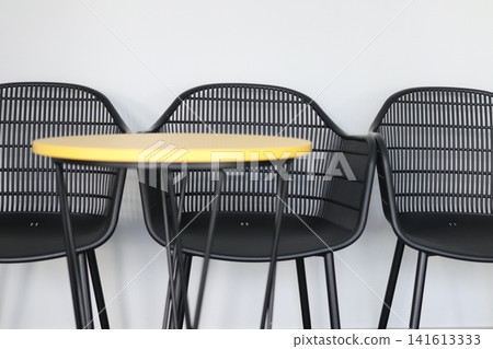 A yellow table and black chairs. A yellow table and black chairs. 141613333