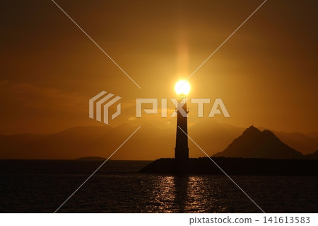 Seascape at sunshine. Lighthouse and sailings on the coast. Seaside town of Turgutreis and spectacular sunshine Seascape at sunshine. Lighthouse and sailings on the coast. Seaside town of Turgutreis and spectacular sunshine 141613583