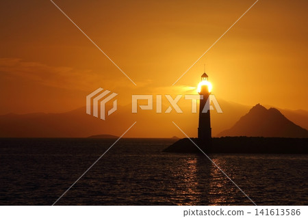 Seascape at sunshine. Lighthouse and sailings on the coast. Seaside town of Turgutreis and spectacular sunshine Seascape at sunshine. Lighthouse and sailings on the coast. Seaside town of Turgutreis and spectacular sunshine 141613586