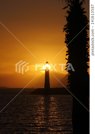 Seascape at sunshine. Lighthouse and sailings on the coast. Seaside town of Turgutreis and spectacular sunshine Seascape at sunshine. Lighthouse and sailings on the coast. Seaside town of Turgutreis and spectacular sunshine 141613587