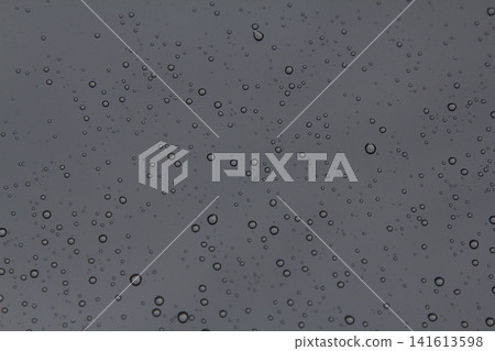 Rain drops on the glass in the spring afternoon. Close up of a window with rain drops falling down.The rain drops on household windows. Focus on rain drops. concept of sadness, frustration Rain drops on the glass in the spring afternoon. Close up of a window with rain drops falling down.The rain drops on household windows. Focus on rain drops. concept of sadness, frustration 141613598