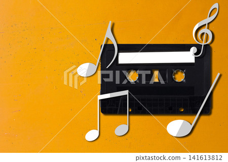 Retro audio cassette tape with paper music notes on yellow background 141613812