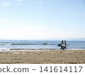 人們帶著衝浪板在湘南海灘漫步，欣賞著平靜的海景。 141614117