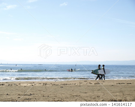 人們帶著衝浪板在湘南海灘漫步，欣賞著平靜的海景。 141614117