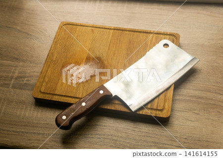 Kitchen knife and chopping board on wooden table. Toned. Kitchen knife and chopping board on wooden table. Toned. 141614155