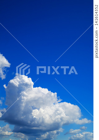 massive white cumulus cloud in the lower left corner against a clear blue sky massive white cumulus cloud in the lower left corner against a clear blue sky 141614352