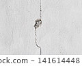 cracked white concrete wall texture with damaged cement surface and hole 141614448