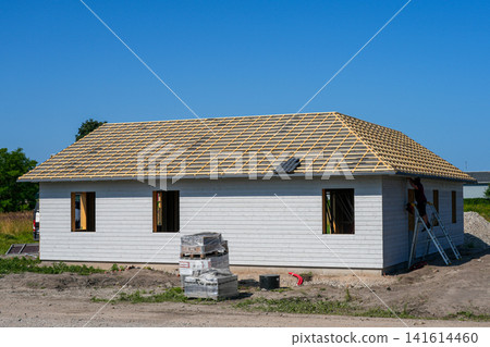 Modern timber frame house with roof battens ready for roofing during residential construction project work Modern timber frame house with roof battens ready for roofing during residential construction project work 141614460
