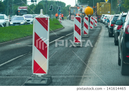 Road Repair Zone with Traffic Barriers Causing Urban Traffic Congestion During Street Reconstruction Work Road Repair Zone with Traffic Barriers Causing Urban Traffic Congestion During Street Reconstruction Work 141614465