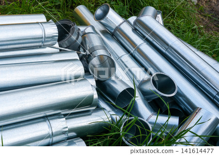 Stack of Galvanized Rainwater Gutters and Downpipe Components Ready for Roof Drainage Installation Site Stack of Galvanized Rainwater Gutters and Downpipe Components Ready for Roof Drainage Installation Site 141614477
