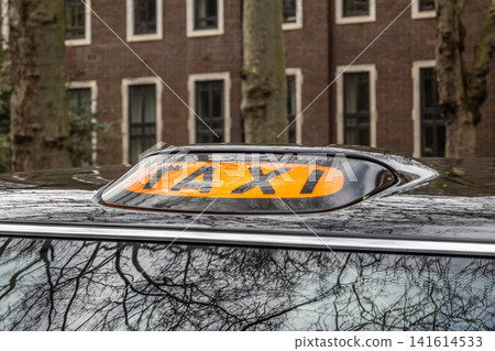 Taxi roof light on black vehicle parked in city Taxi roof light on black vehicle parked in city 141614533