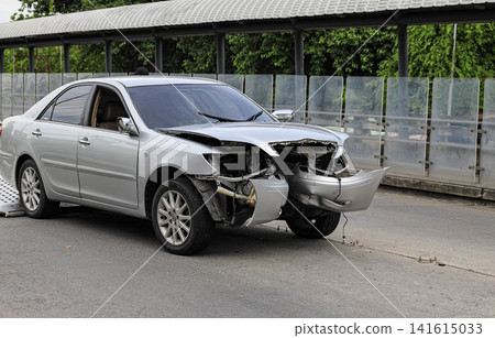 Traffic Accident Resulting in a Crushed Car, Front-facing view of a sedan with extensive front-end damage following a collision. Traffic Accident Resulting in a Crushed Car, Front-facing view of a sedan with extensive front-end damage following a collision. 141615033