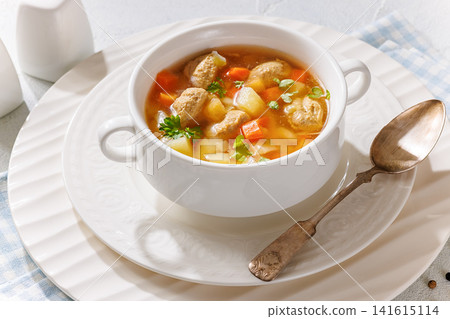 Old fashioned poultry meatball soup in clear broth Old fashioned poultry meatball soup in clear broth 141615114