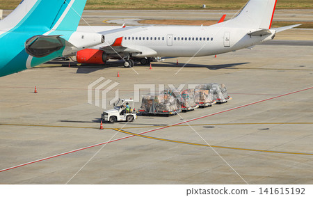 Baggage Tug( baggage dolly transport ) on duty in ground handling services. Baggage Tug( baggage dolly transport ) on duty in ground handling services. 141615192