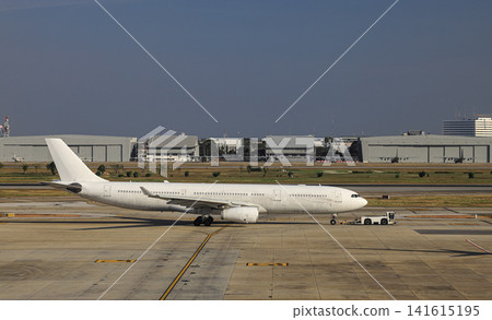 White aircraft are pushed back to the taxiway by airplane tugs, with one in ground handling services. White aircraft are pushed back to the taxiway by airplane tugs, with one in ground handling services. 141615195