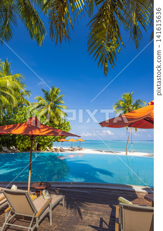 Elegant tropical infinity pool with red umbrella and loungers framed by palm trees turquoise ocean blue sky. Perfect summer vacation travel resort paradise. Luxury getaway relax scenic Elegant tropical infinity pool with red umbrella and loungers framed by palm trees turquoise ocean blue sky. Perfect summer vacation travel resort paradise. Luxury getaway relax scenic 141615636
