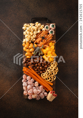 Halloween snack board with spooky candy on rustic background Halloween snack board with spooky candy on rustic background 141615705