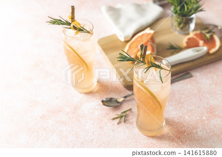 Two glasses of Paloma cocktails with tequila fresh grapefruit juice combined and rosemary. Festive drink is ideal for brunch, parties and holidays Two glasses of Paloma cocktails with tequila fresh grapefruit juice combined and rosemary. Festive drink is ideal for brunch, parties and holidays 141615880