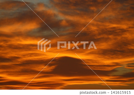 Blurry background of red sunset sky. Dramatic sky with colorful cloud background. Red burning sunset sky. Copy space. Blurry background of red sunset sky. Dramatic sky with colorful cloud background. Red burning sunset sky. Copy space. 141615915