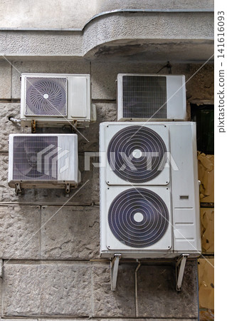 Air conditioners hanging on building facade Air conditioners hanging on building facade 141616093