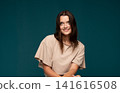Young brunette woman smiling cheerfully, feeling happy and positive, representing youth, natural beauty and wellbeing 141616508
