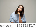 Young woman thinking, looking up with curious expression, finding solution, contemplating idea or choice 141616517