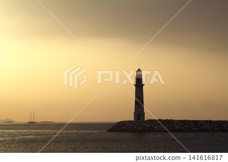 Seascape at sunshine. Lighthouse and sailings on the coast. Seaside town of Turgutreis and spectacular sunshine Seascape at sunshine. Lighthouse and sailings on the coast. Seaside town of Turgutreis and spectacular sunshine 141616817