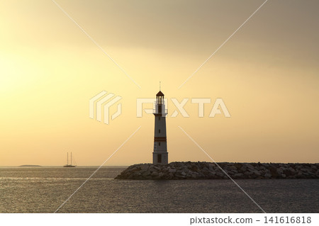 Seascape at sunshine. Lighthouse and sailings on the coast. Seaside town of Turgutreis and spectacular sunshine Seascape at sunshine. Lighthouse and sailings on the coast. Seaside town of Turgutreis and spectacular sunshine 141616818